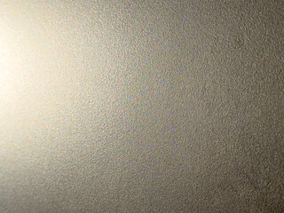 Glitzernde, leicht unregelmäßige Oberfläche unter starkem Licht