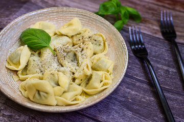 Home made vegetarian  italian   Tortellini with pesto genovese filled with   spinach   and parmesan cheese, decorated with fresh basil