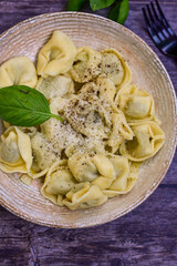 Home made vegetarian  italian   Tortellini with pesto genovese filled with   spinach   and parmesan cheese, decorated with fresh basil
