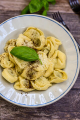 Home made vegetarian  italian   Tortellini with pesto genovese filled with   spinach   and parmesan cheese, decorated with fresh basil