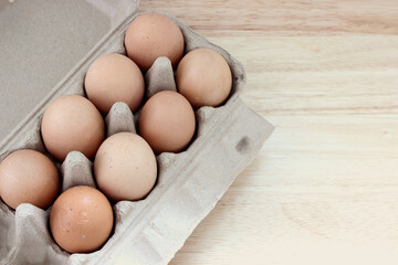 The organic eggs in egg tray on the wooden table