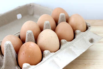 The organic eggs in egg tray on the wooden table