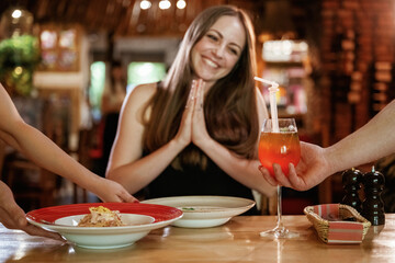 The waiters brought the food. Woman is in the restaurant