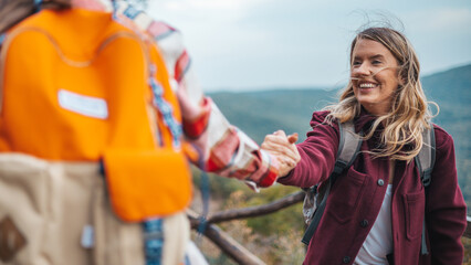 Help hands, friends or women hiking up a mountain, hill or in nature with a smile. Travel,...