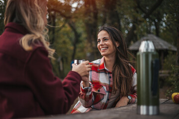 Group of friends on country walk. Young people hiking in countryside. Front view with lens flare of  Caucasian female friends in 20s and 30s smiling as they enjoy late afternoon day hike.
