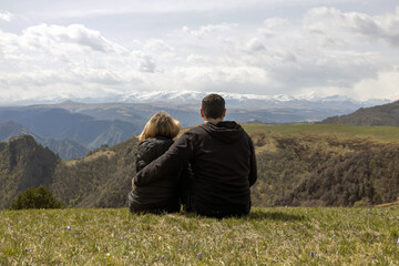 Fototapeta premium Man and woman walking along tourist route high in mountains. Beautiful background for banner. Weekend trip