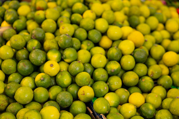 Green limes are offered at the weekly market in Rotterdam. Healthy food, citrus fruits, ripe, market stall, trader, food.