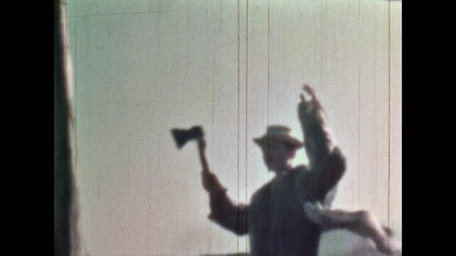 Archival film, male saboteur conceived by surprise, raises his hands in fear, throw axe weapon toward enemy. Adventure old movie. Aggression in outdated films. Fictional thrillers. Vintage retro 1960s