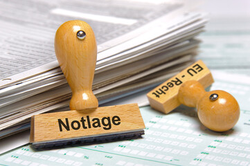 Ein Holzstempel ist beschriftet mitdem Aufdruck: Notlage