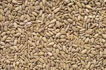 Heap of peeled sunflower seeds background texture.