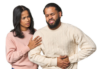 Young Latino couple in studio having a liver pain, stomach ache.