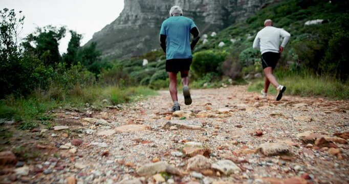 Mature man, friends and running with mountain trail in fitness, exercise or outdoor workout in nature. Back view of senior, male person or runner in trekking, training or hiking on rock path together