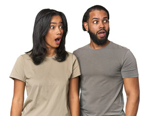 Fototapeta premium Young Latino couple in studio being shocked because of something she has seen.