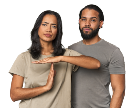 Young Latino couple in studio showing a timeout gesture.