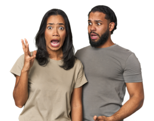 Young Latino couple in studio screaming to the sky, looking up, frustrated.