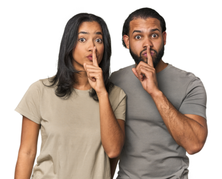 Young Latino couple in studio keeping a secret or asking for silence.