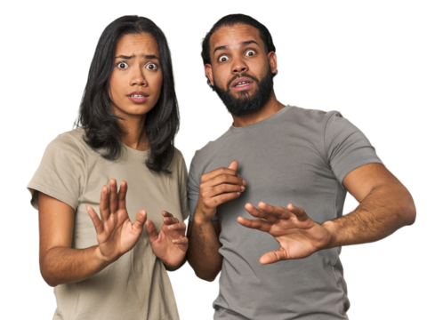 Young Latino couple in studio being shocked due to an imminent danger