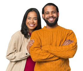 Young Latino couple in studio who feels confident, crossing arms with determination.