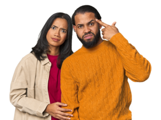 Young Latino couple in studio holding and showing a product on hand.