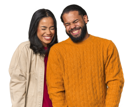 Young Latino couple in studio laughs and closes eyes, feels relaxed and happy.