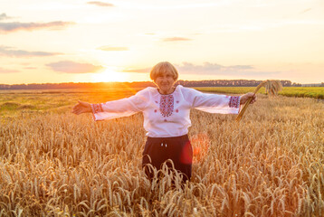 Woman in a wheat field wearing an embroidered shirt. Selective focus.