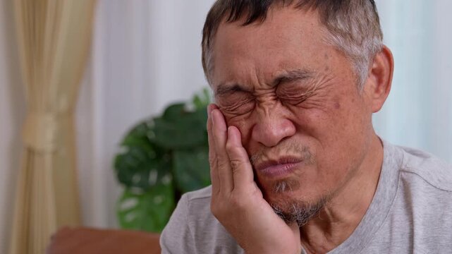 Asia old senior men suffering from severe toothache, holding him cheek and suffering strong dental pain on white background, tooth decay, tooth sensitivity, oral health care concept.