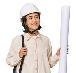 Young Caucasian female architect with blueprints in studio