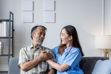 Obraz premium Young female nurse comforting senior male patient at home