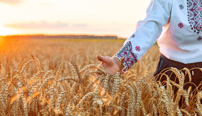 Woman in a wheat field wearing an embroidered shirt. Selective focus.