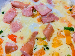 Scrambled eggs with vegetables and sausage.