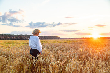 Woman in a wheat field wearing an embroidered shirt. Selective focus.