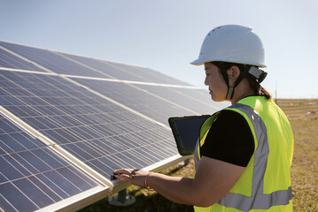 female technician working with tablet in solar power station