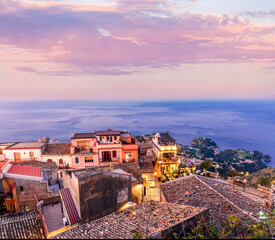 Obraz premium beautiful travel town view from a mountain to roofs and houses, valley and sea gulf with scenic cloudy sunrise or sunset on background of landscape