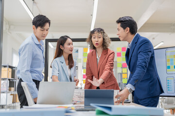 Creative Asian professionals brainstorming in a modern office. Business team collaborating on...