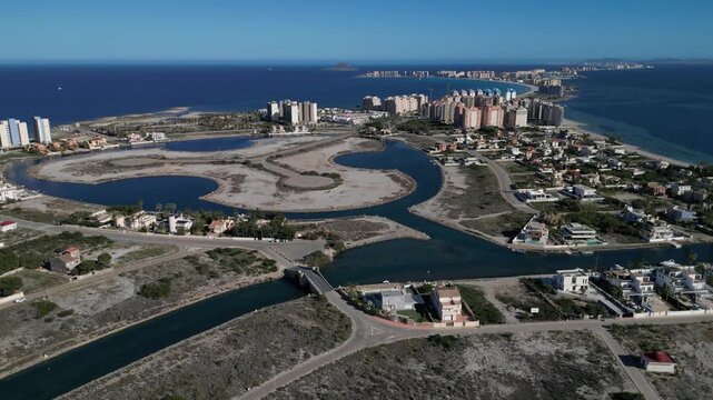 View on the canal in Mar Menor and an interesting arched bridge Puente de La Risa in the midst of a hot day.