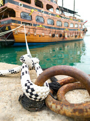 Close-up of mooring cable node of ship, holding moored vessel, symbol of reliability, vertical frame.
