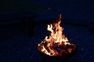 Obraz premium close up of fire flame in a campfire of burning wood charcoal at night in an outdoor area