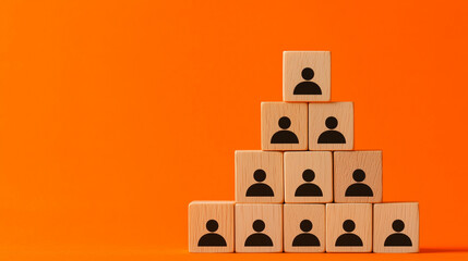 Wooden blocks with human icons arranged in a pyramid shape on an orange background, representing team structure, hierarchy, and organization.
