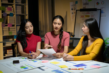 Three Young Women Collaborating on a Business Project in a Modern Office Environment