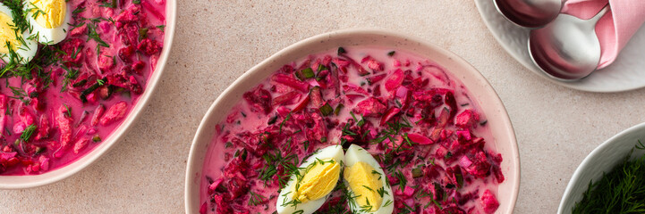 Summer cold beetroot soup made from beets, radishes, cucumbers, potatoes and herbs, garnished with...