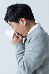 鼻をかむ50代男性