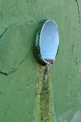 A sewer on the green concrete wall