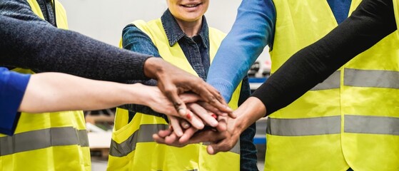Industrial workers celebrating stacking hands together at factory warehouse. Business people, technology and construction team concept