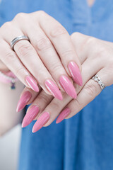 Woman hand with long nails manicure and light pink nail polish