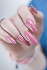 Woman hand with long nails manicure and light pink nail polish