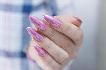 Woman hand with long nails manicure and light pink nail polish