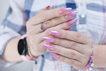 Woman hand with long nails manicure and light pink nail polish