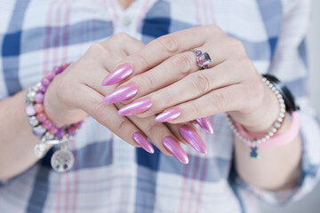 Woman's hands with long nails and light pink manicure 