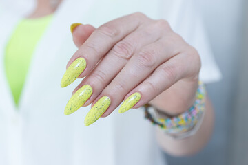 Female hand with long nails and neon yellow green manicure