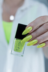 Female hand with long nails and neon yellow green manicure